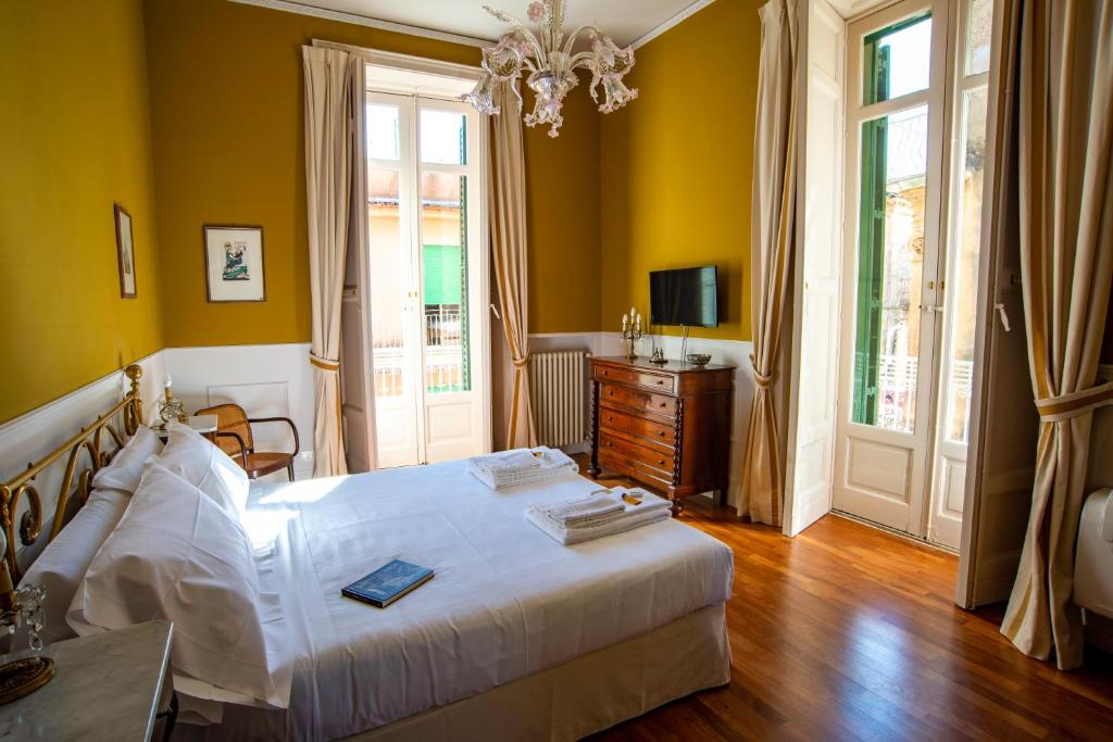 拉古萨I Sogni della Memoria的卧室设有白色的床和黄色的墙壁