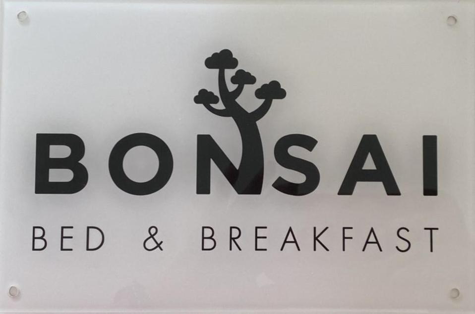 佩萨罗Bonsai - Bed & Breakfast的上面有树的住宿加早餐旅馆标志