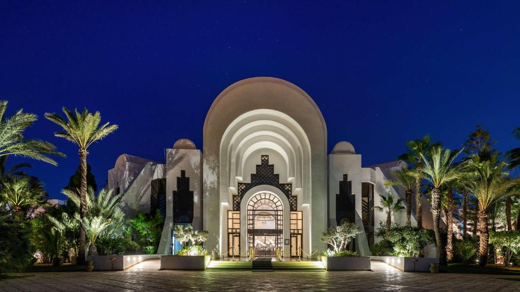 乌姆苏克杰尔巴皇宫丽笙度假酒店及海水浴的棕榈树建筑的夜景