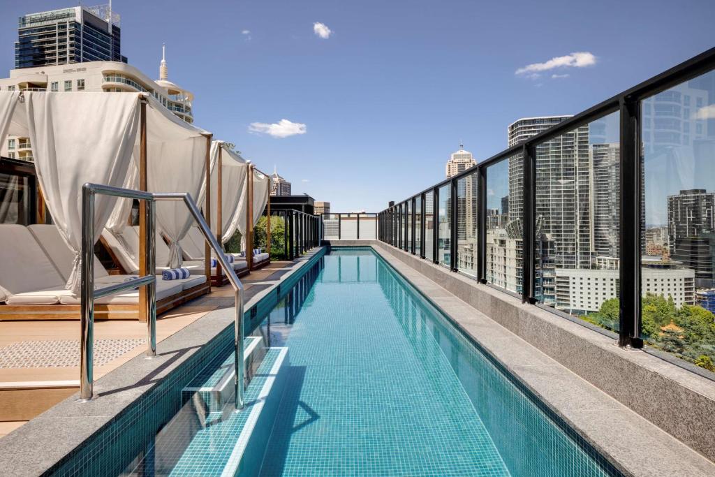 悉尼Vibe Hotel Sydney Darling Harbour的建筑物屋顶上的游泳池