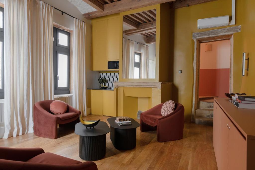 里昂MiHotel Saint Jean的客厅配有两把椅子和壁炉