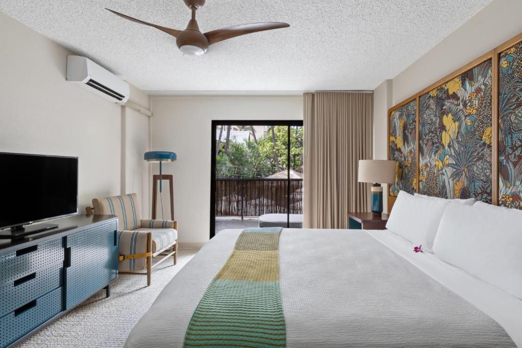檀香山White Sands Hotel的一间带大床和电视的卧室