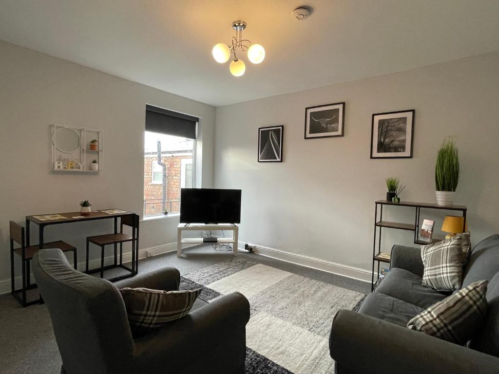 LincolnshireWindmill View Apartments的客厅配有两张沙发和一台电视机