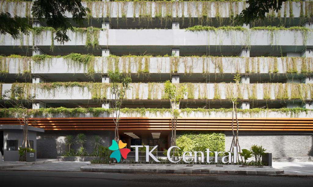 金边TK Central Serviced Apartments的一座植物在建筑的一侧