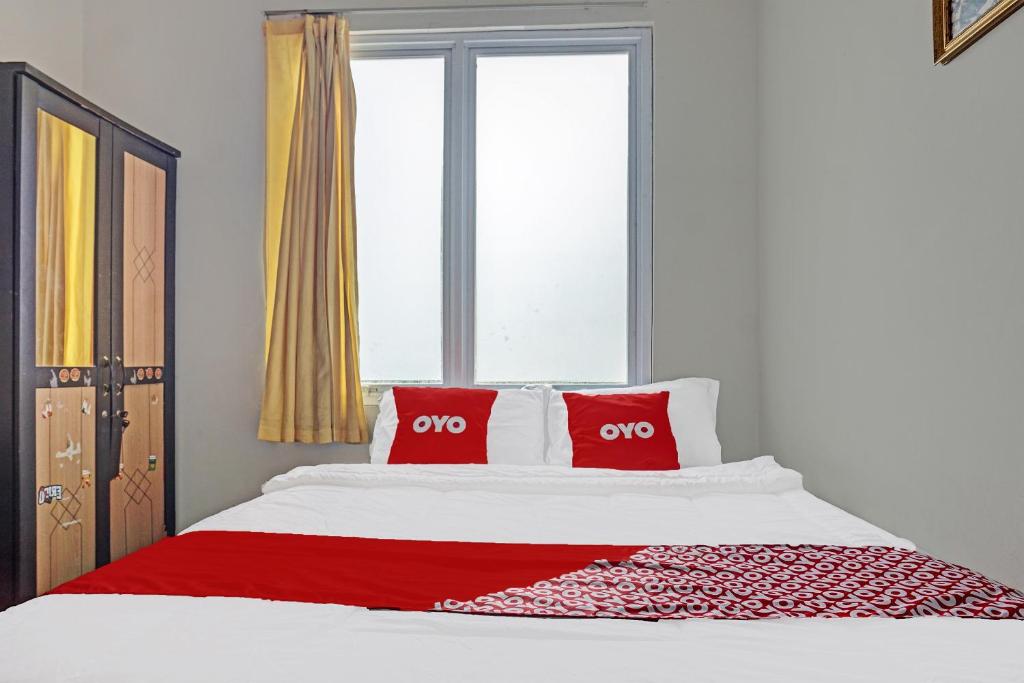 当格浪OYO 91849 Karawaci Taman Permata 5的一间卧室配有一张带两个红色枕头的床
