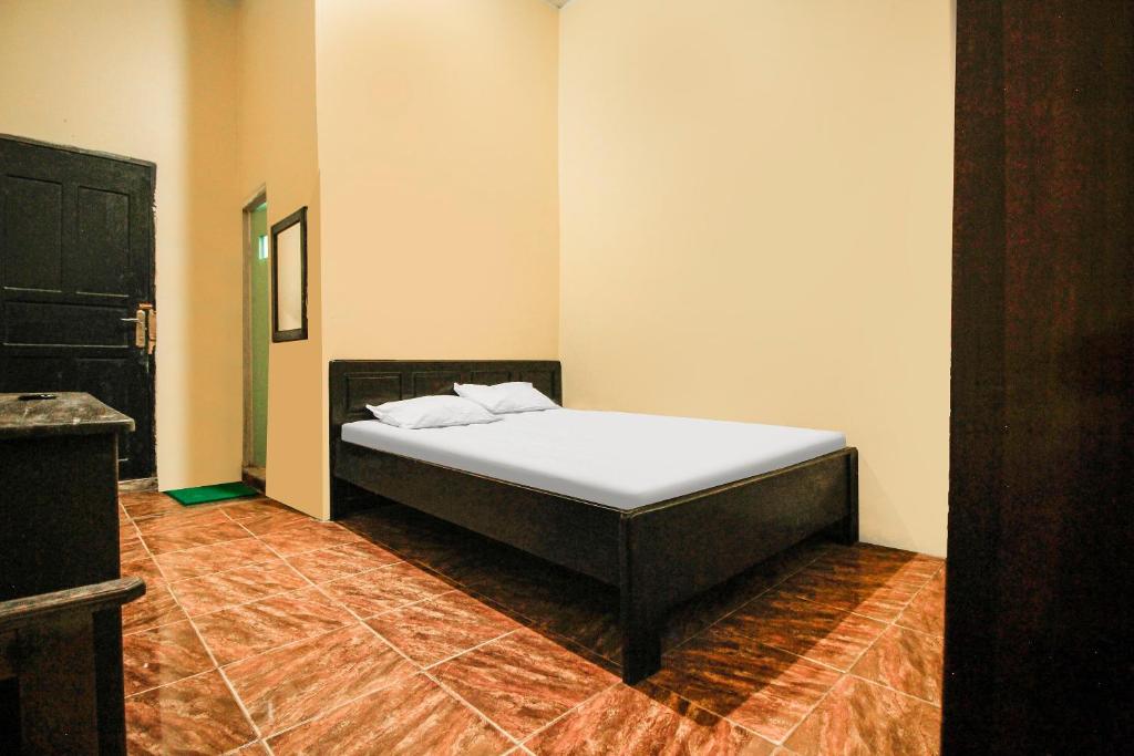 肯达利OYO 91855 Big Hotel Kendari的卧室位于客房的角落,配有一张床