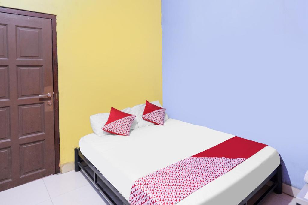 名古屋SPOT ON 91887 Penginapan Rindu的一间卧室配有一张床、一扇门和一张床