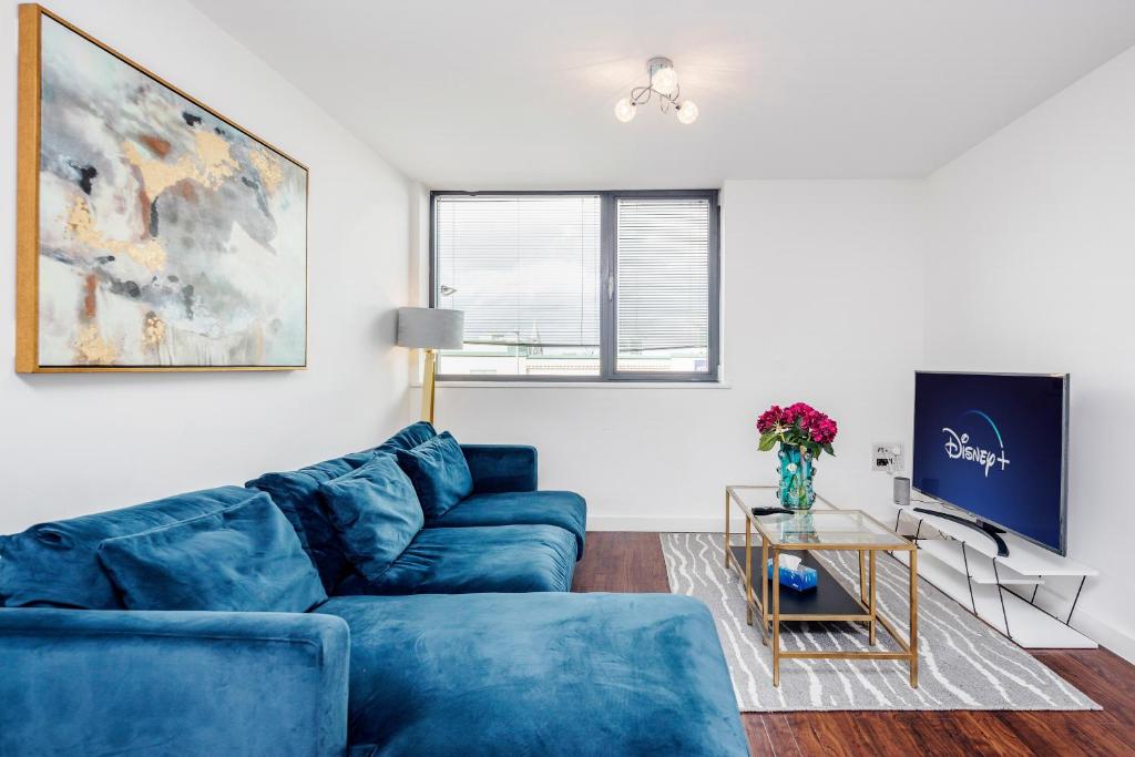 巴塞尔顿2-Bed Apartment Near Basildon Train Station的客厅配有蓝色的沙发和电视