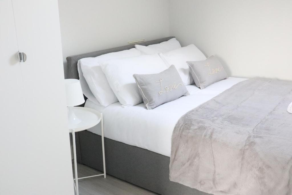 South NorwoodTwelve Thirty Serviced Apartments - 1 Croydon的一间卧室配有带白色床单和枕头的床。