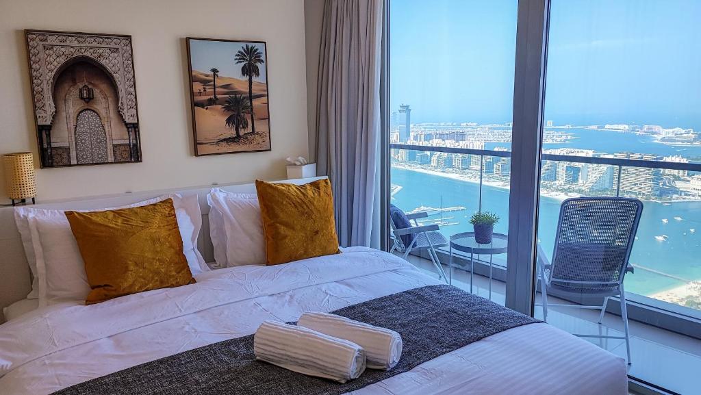 迪拜Exquisite, luxe 1BD Apartment, Unparalleled Sea Views, Prime Dubai Marina Location & Full Kitchen by "La Buena Vida Holiday Homes的一间卧室配有一张床,享有海景