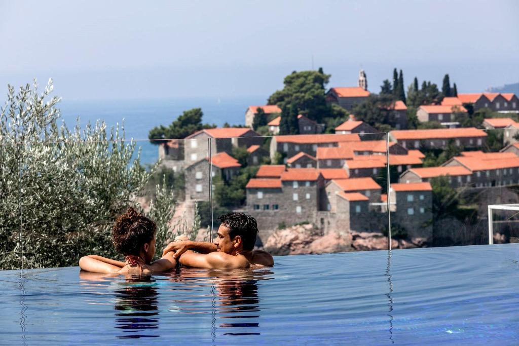 斯韦蒂·斯特凡Villa Geba Boutique Hotel的两人坐在游泳池的水中