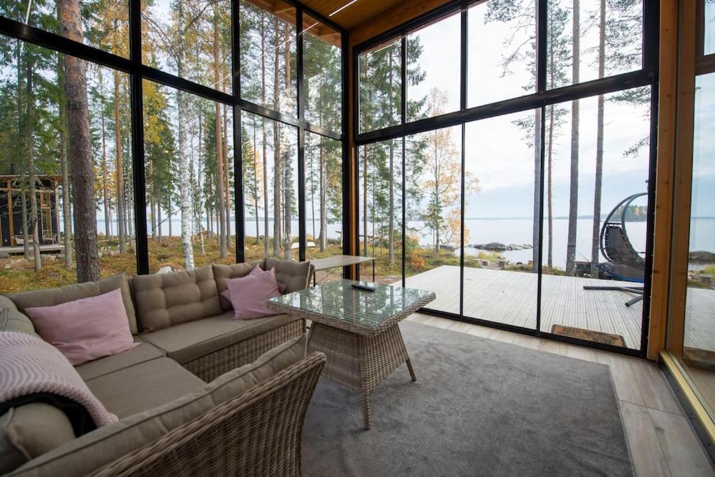AlvajärviRantarovio的带沙发和玻璃桌的客厅