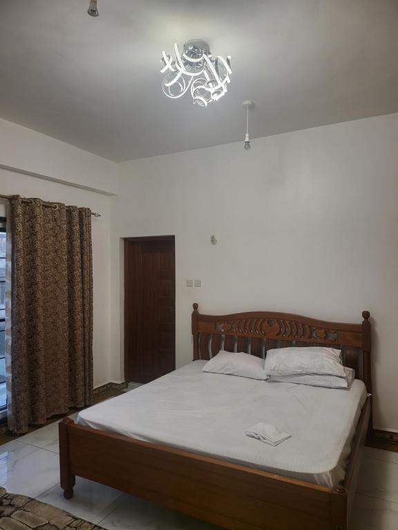 蒙巴萨Meshaal heights的一间卧室配有一张位于上面的光线的床