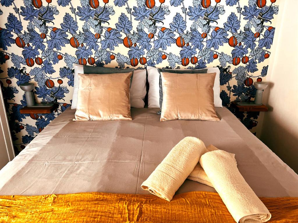 比萨San Ranieri Tiny Tower的一张带两个枕头的床和蓝色和橙色的墙壁