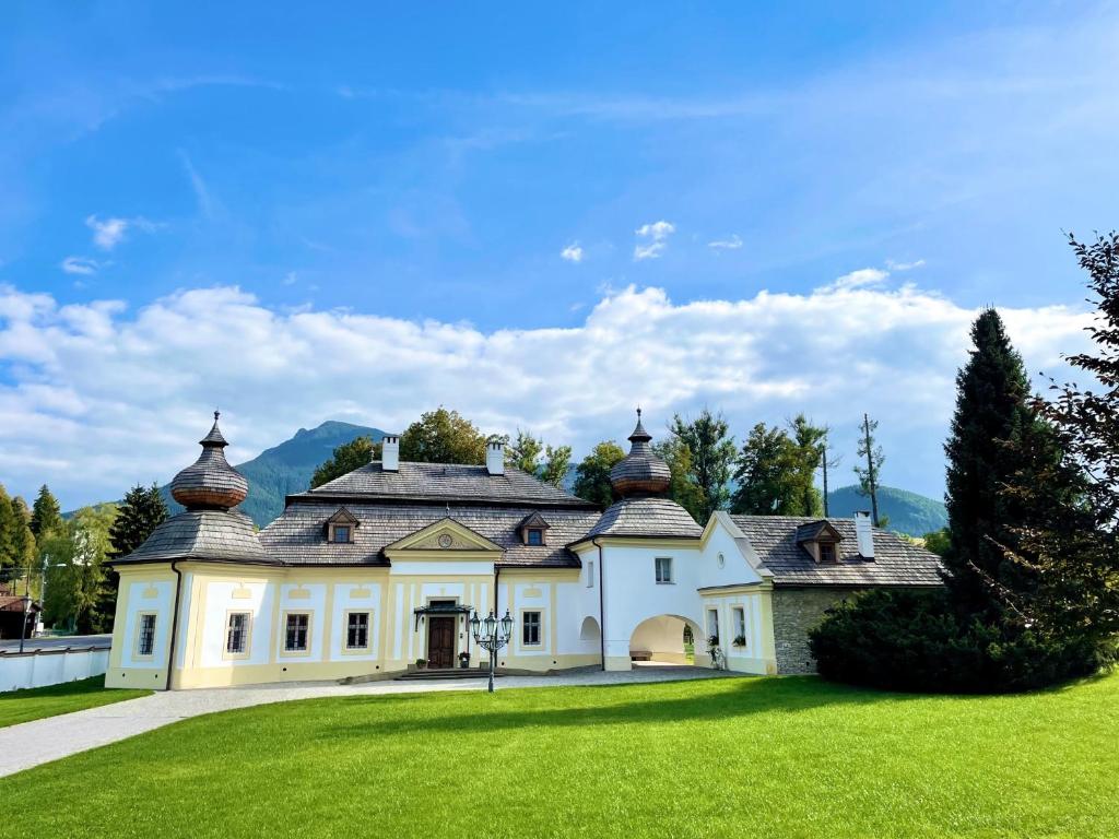 道尼库宾Kaštieľ Kubínyi的一座带绿色草坪的大型白色房屋