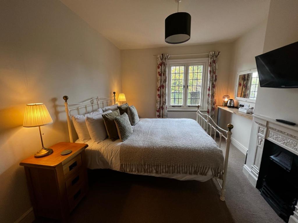 奥尔顿白鹿宾馆的一间卧室配有一张床和一张带台灯的桌子