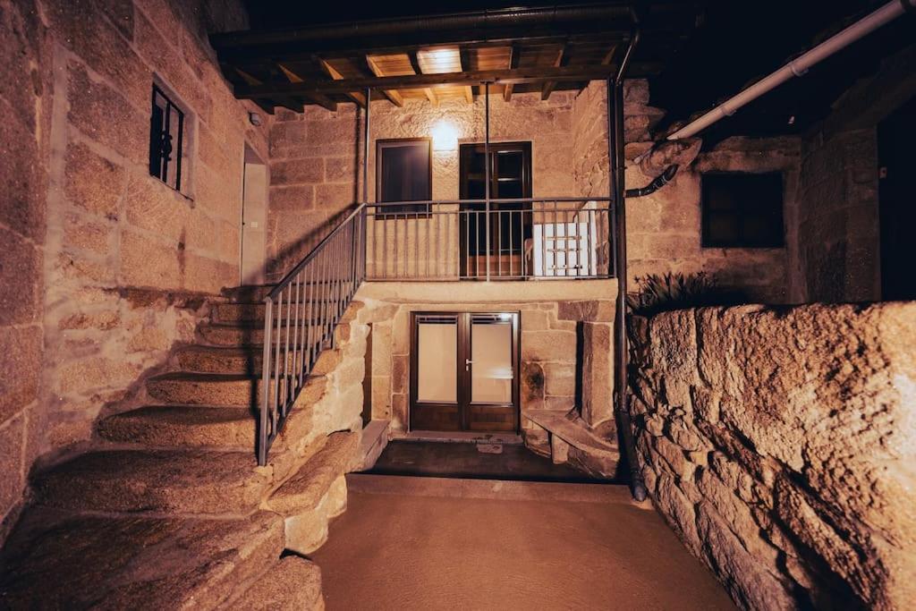 奥伦塞Casa Rural Vilar de Flores的一座带楼梯和阳台的石头建筑