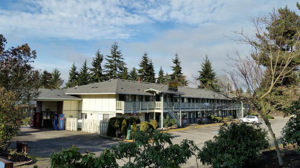 皮阿拉普普亚鲁普汽车旅馆的一座白色的大建筑,有停车场和树木