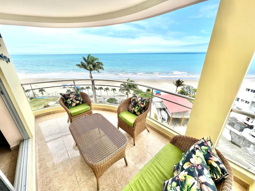 通苏帕Encantador departamento frente al mar con WIFI的一个带椅子的阳台,享有海滩美景