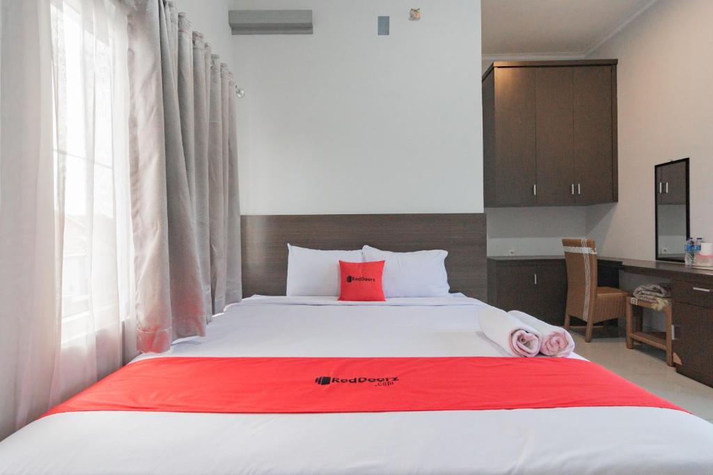井里汶RedDoorz Plus Syariah @ Tuparev Cirebon 3的卧室配有一张大白色床和红色毯子