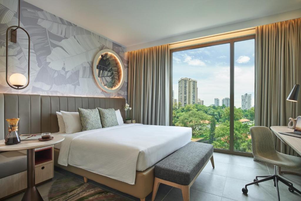 新加坡Citadines Connect Rochester Singapore的配有一张床、一张书桌和一扇窗户的酒店客房