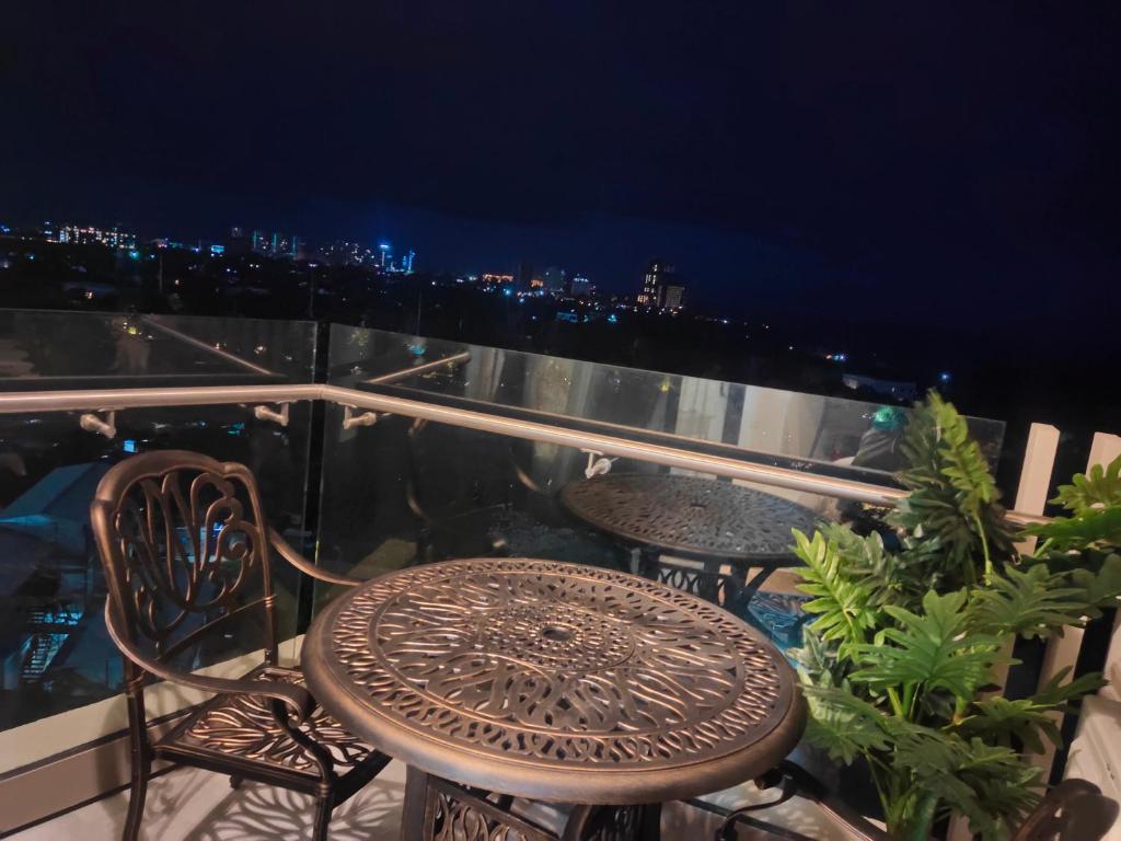 MaribagoTambuli Residence的夜间阳台上的桌椅