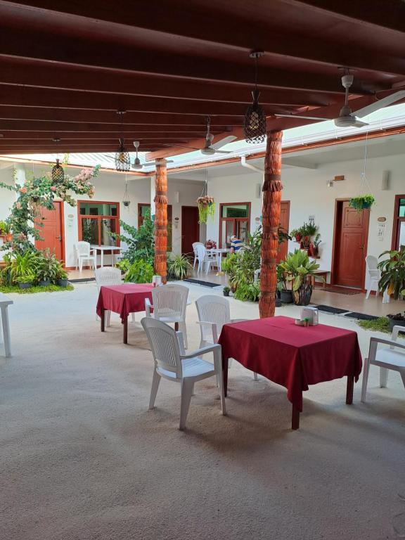 图杜Summer Sky Thoddoo的一个带桌椅和红色桌布的庭院
