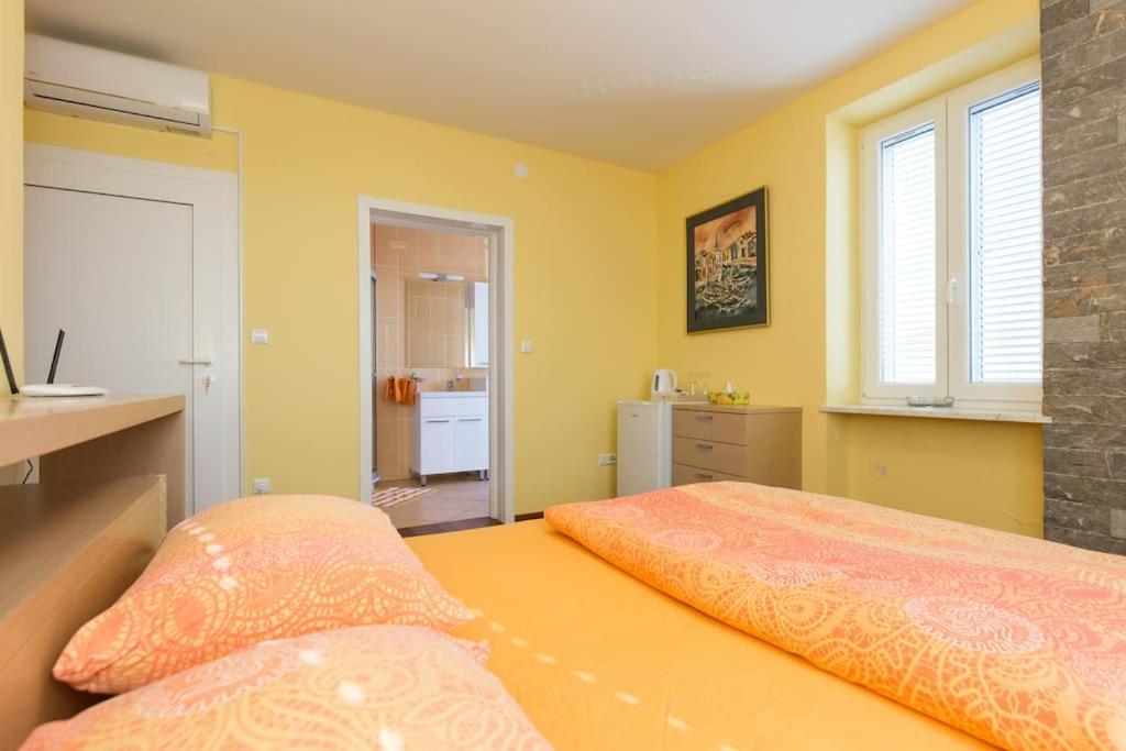 奥米沙利Villa Ajda - Orange room的一间卧室设有两张黄色墙壁的床