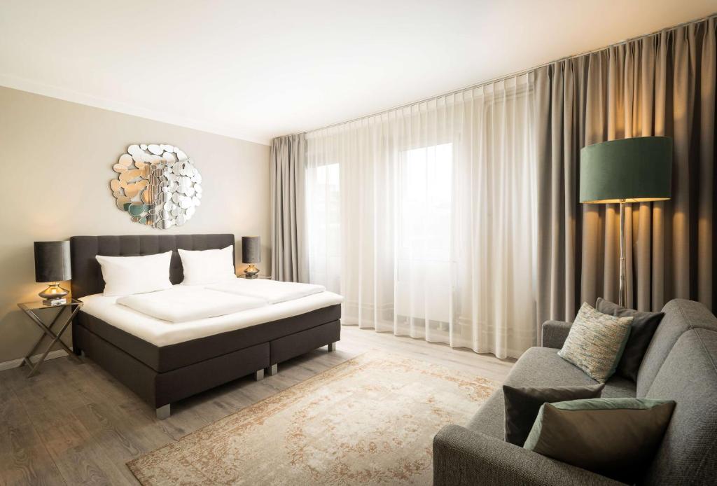 汉诺威elaya hotel hannover city的一间卧室配有一张床和一张沙发