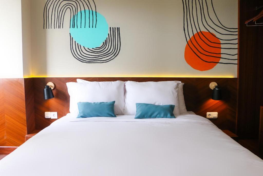 KaliastanaStay G Service Residence Jatibening的卧室配有带蓝色枕头的大型白色床