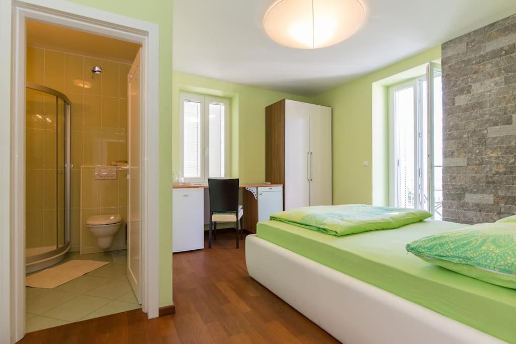 奥米沙利Villa Ajda - Green room的一间卧室配有一张床,浴室设有淋浴。
