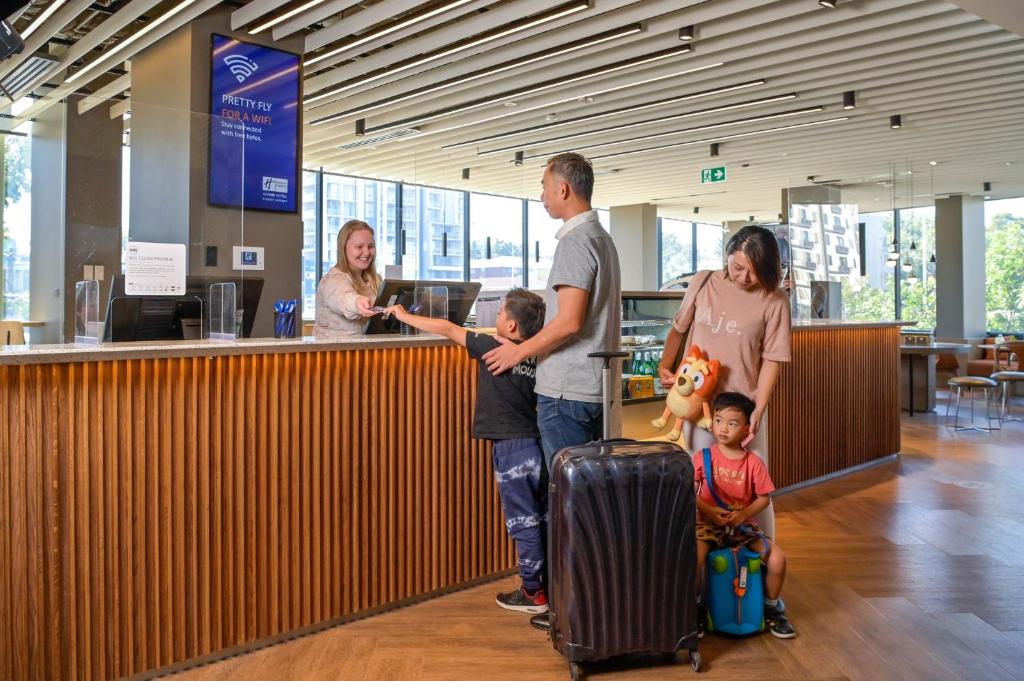 悉尼Holiday Inn Express Sydney Airport, an IHG Hotel的一群人带着行李站在机场