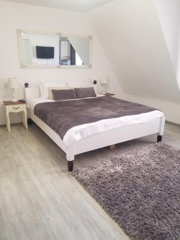 锡比乌A&A Central Apartment的卧室配有一张白色大床和地毯。