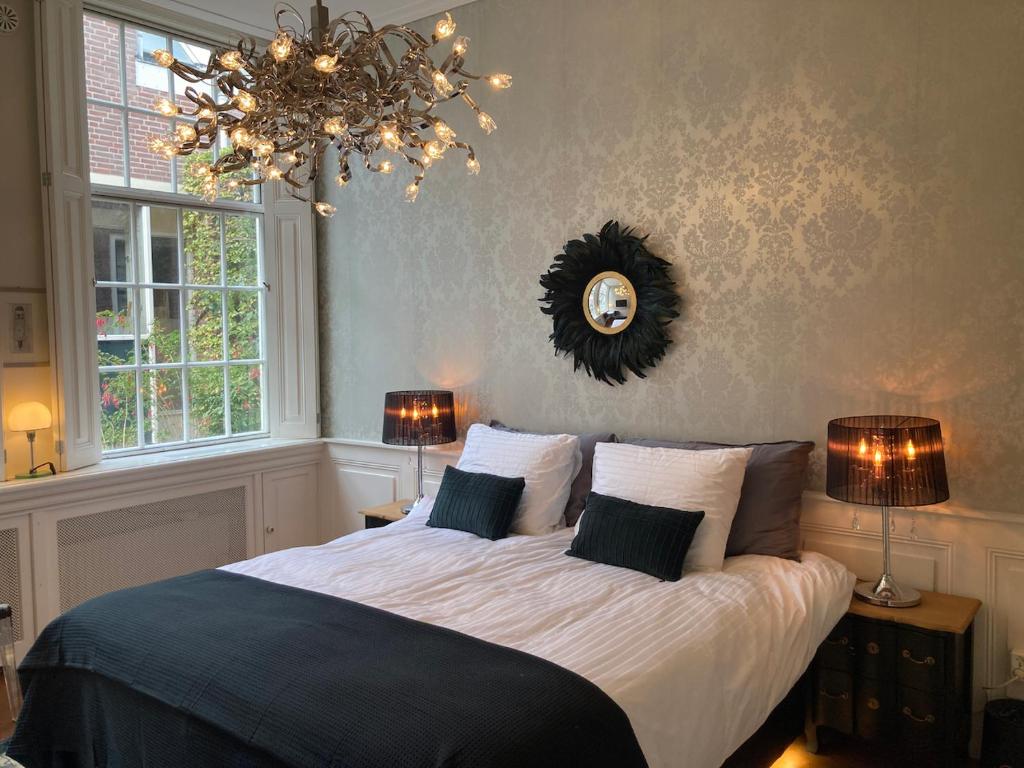 哈莱姆GuesthouseOne的一间卧室配有一张大床、两盏灯和吊灯。