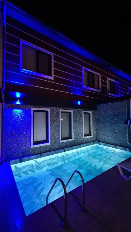 达拉曼Villa Koyuncu的夜晚的游泳池,灯光蓝色