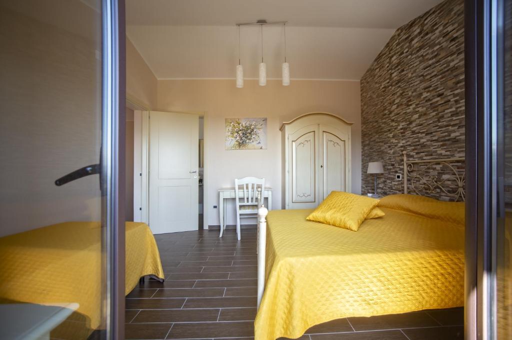 MalvitoB&B MALVETUM的一间卧室设有黄色的床和砖墙