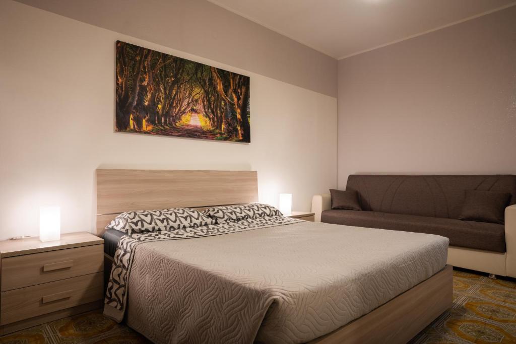 塞斯托拉Loft in Centro con Camino - Sestola的一间卧室配有一张床和一张沙发