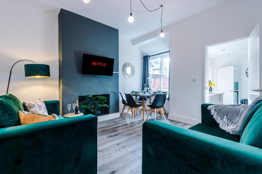 克鲁Spacious 4-bed house in Crewe by 53 Degrees Property, ideal for Business & Contractors - Sleeps 7的客厅配有两张绿色沙发和一张桌子
