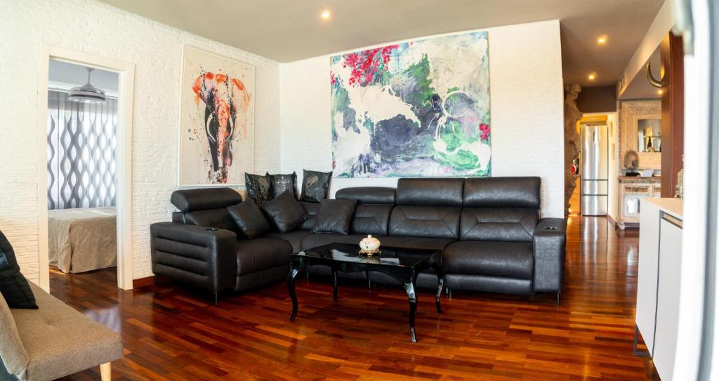 马贝拉Luxury apartamento en río real的客厅配有黑色真皮沙发和桌子
