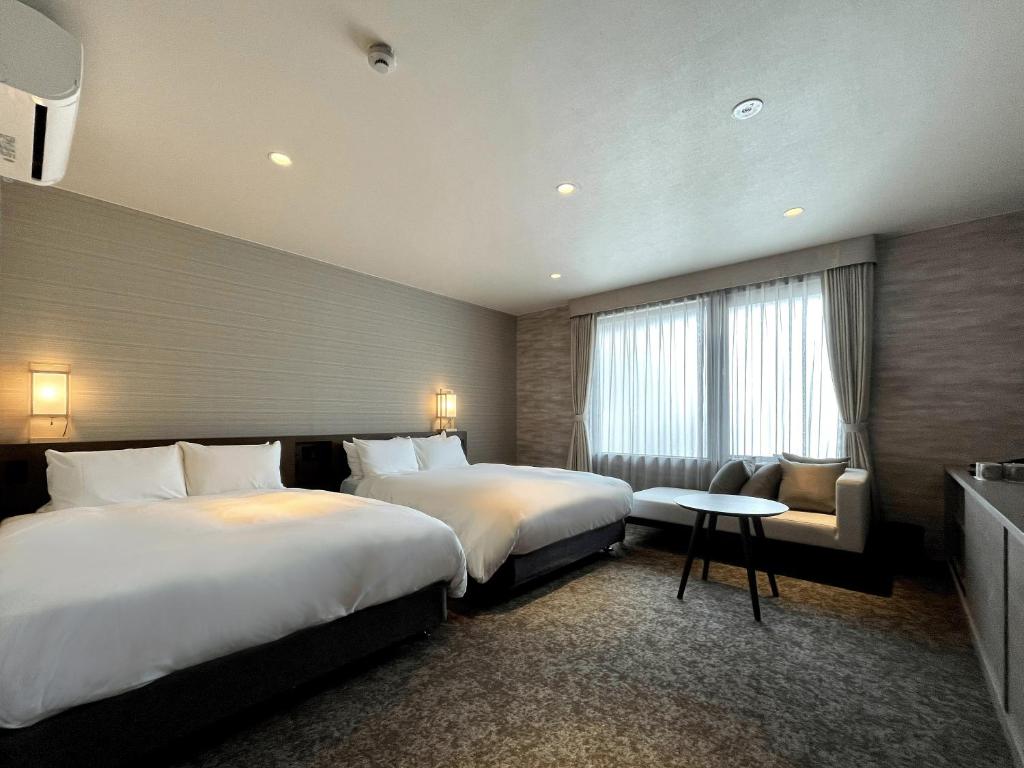 京都Kyoto Granbell Hotel hanareya的酒店客房设有两张床和一张桌子。