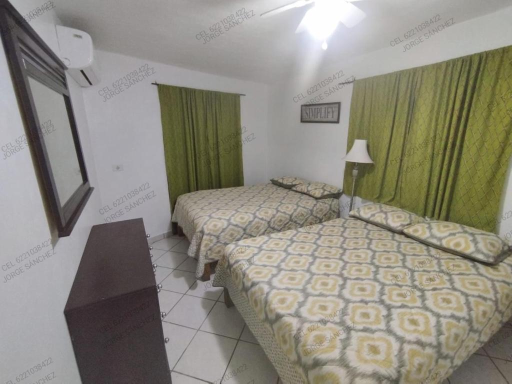 圣卡洛斯Casa Tecalai 5的配有绿窗帘的酒店客房的两张床