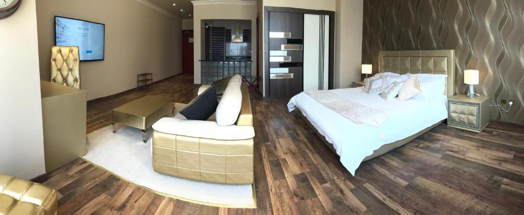 Al WakrahWakra Inn Hotel Apartments的一间卧室配有一张床、一把椅子和一张沙发