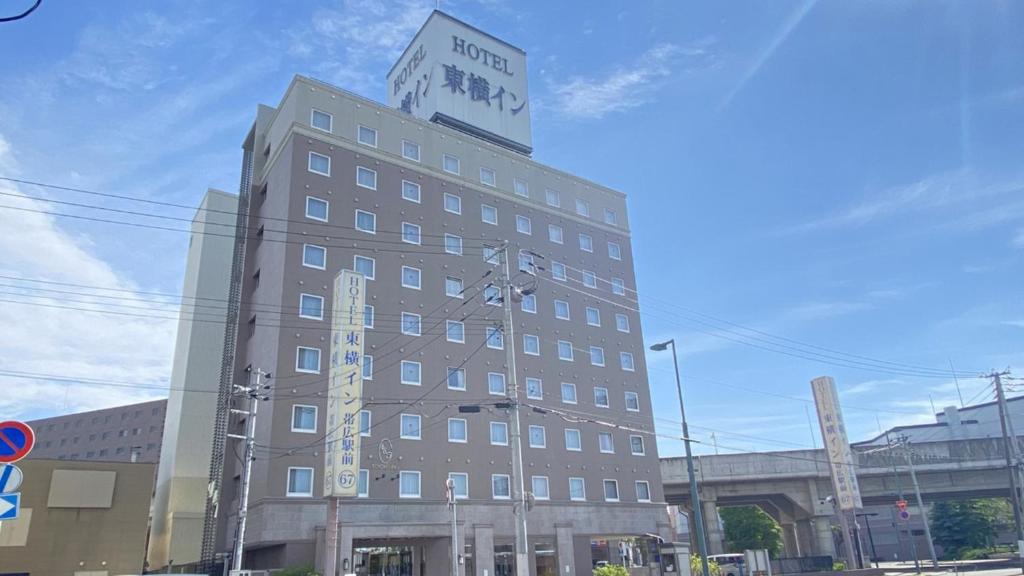 带广Toyoko Inn Hokkaido Tokachi Obihiro Ekimae的一座高大的建筑,上面有钟