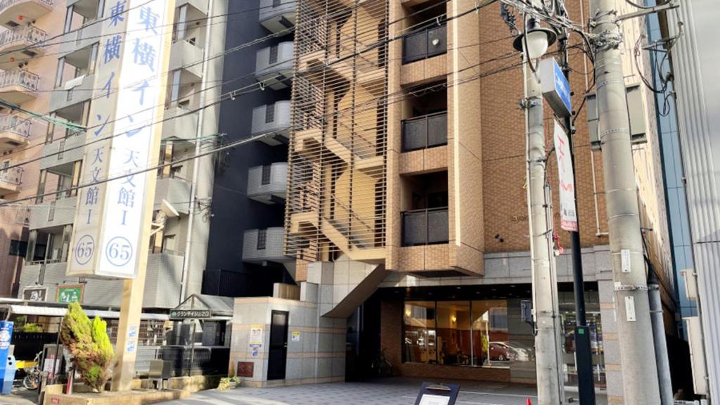 鹿儿岛Toyoko Inn Kagoshima Temmonkan No 1的街道上高大的建筑,有街灯