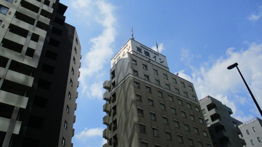 东京Toyoko Inn Tokyo Korakuen Bunkyokuyakusho Mae的一座高大的建筑,上面有天线