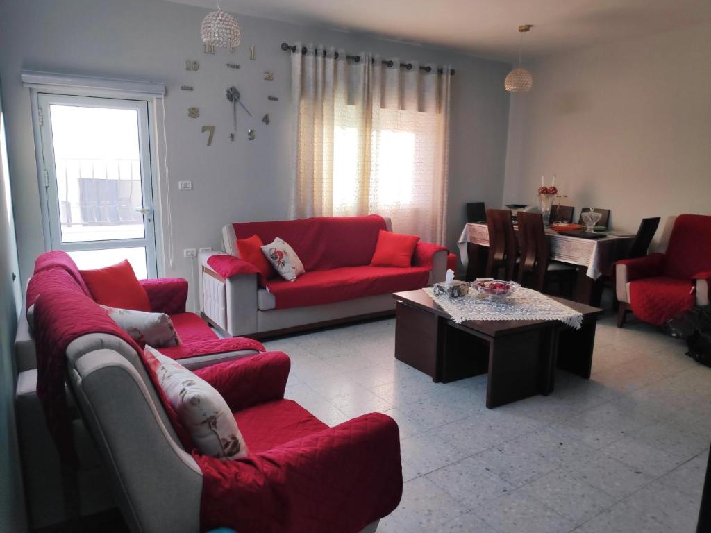 伯利恒Fully Furnished Apartment in Bethlehem Center的客厅配有红色的沙发和桌子