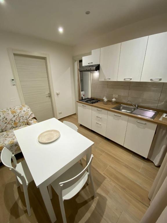 阿格里真托Dimora Garibaldi Apartment & Room的厨房配有桌子和白色的桌椅