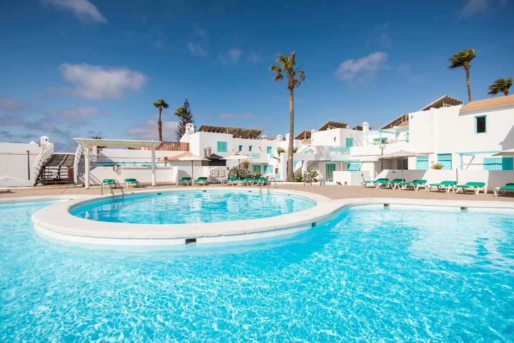卡勒达德福斯特Smy Tahona Fuerteventura的白色建筑前方的蓝色海水大型游泳池