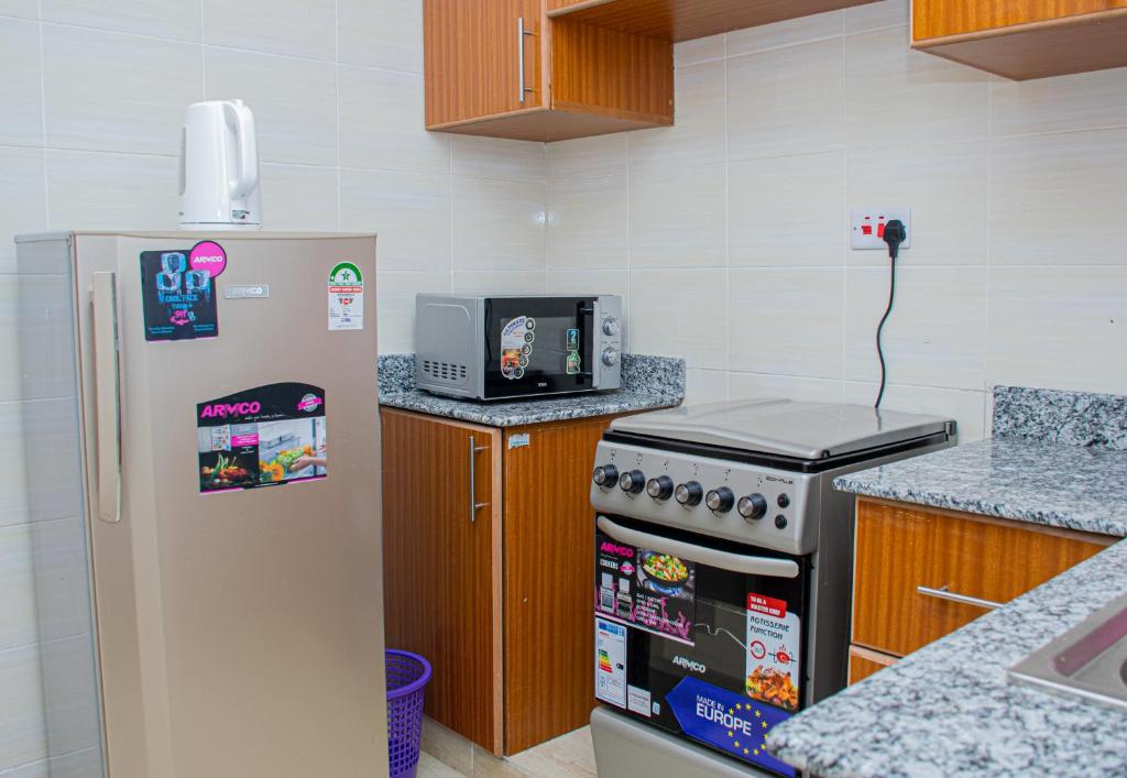 纳库鲁Pearl Suites Apartments的厨房配有冰箱和炉灶。