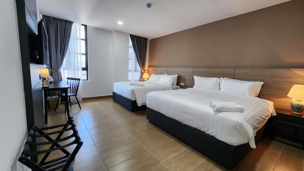 吉隆坡Yu Hotel Chinatown的酒店客房设有两张床、一张桌子和一台电视。
